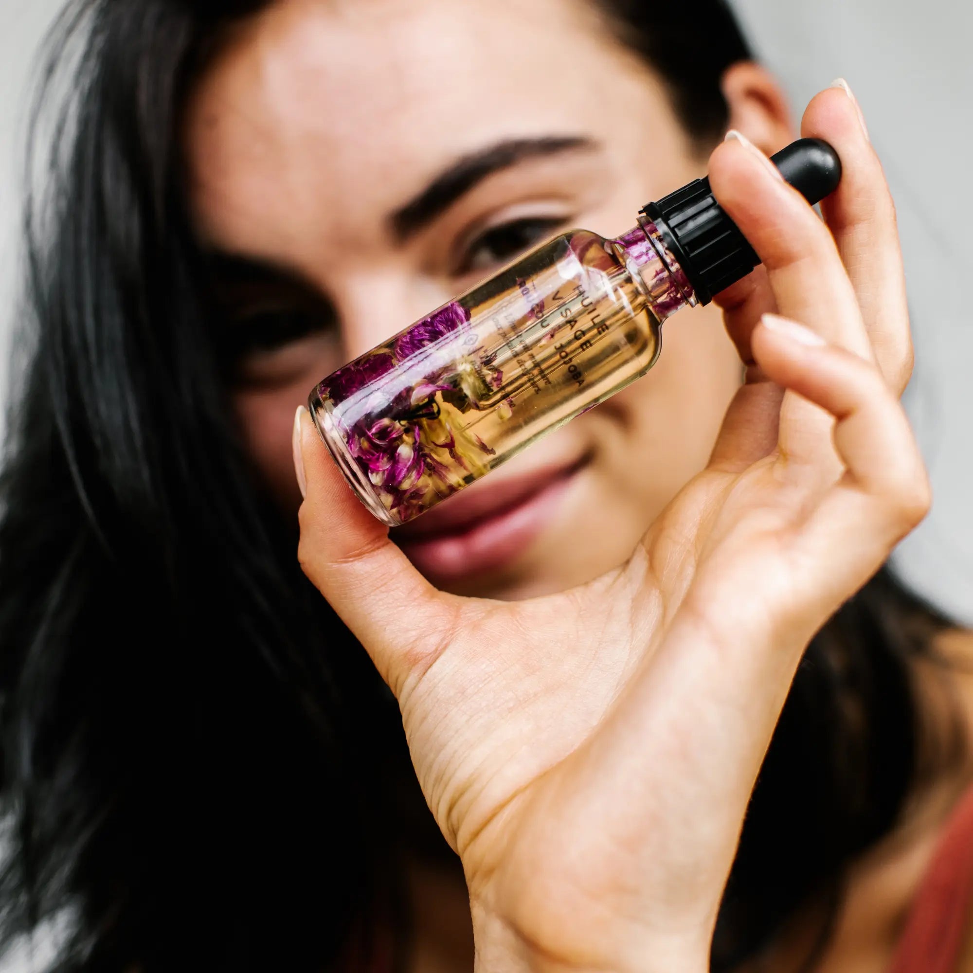 femme tenant huile éclat visage