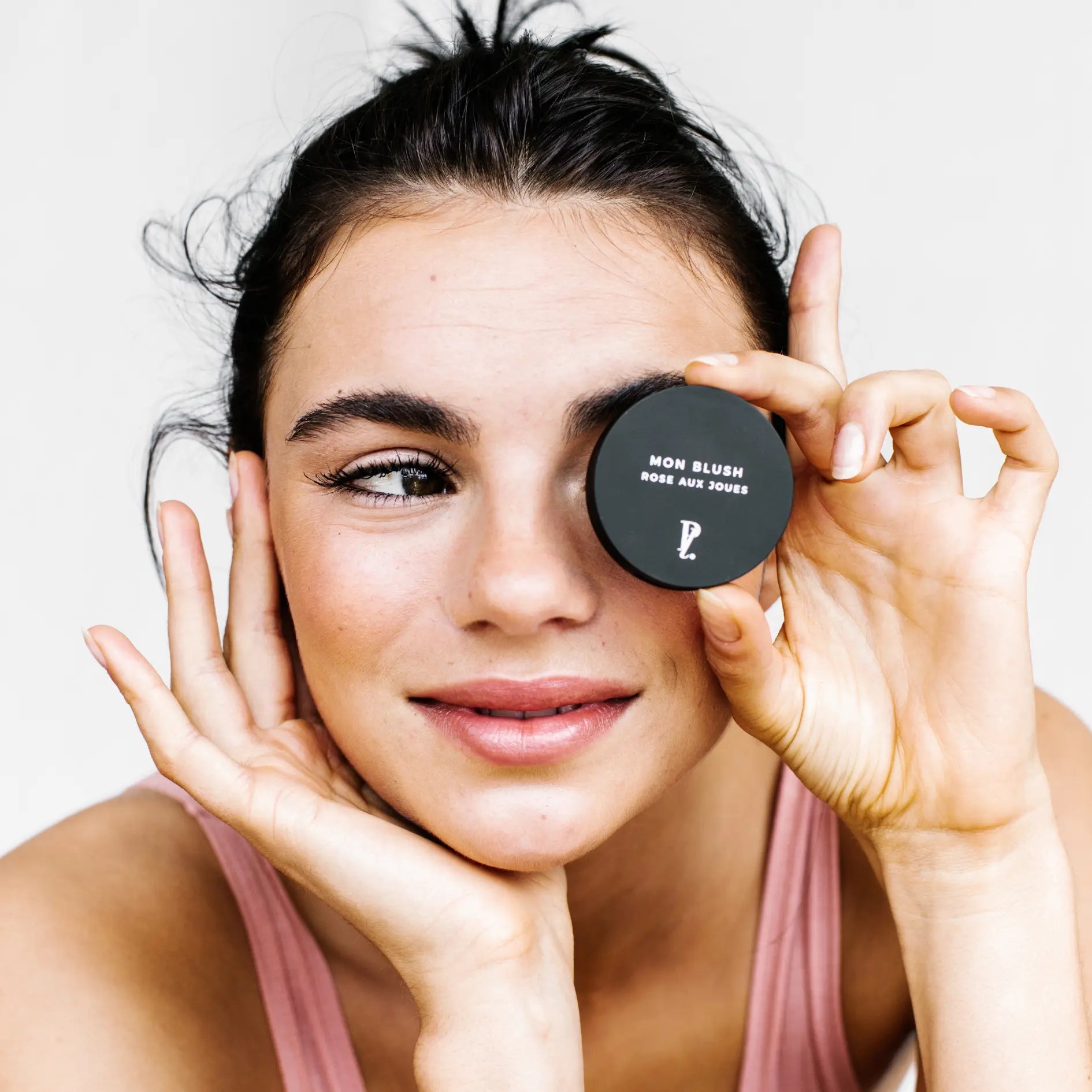 femme tenant blush fermé devant son visage