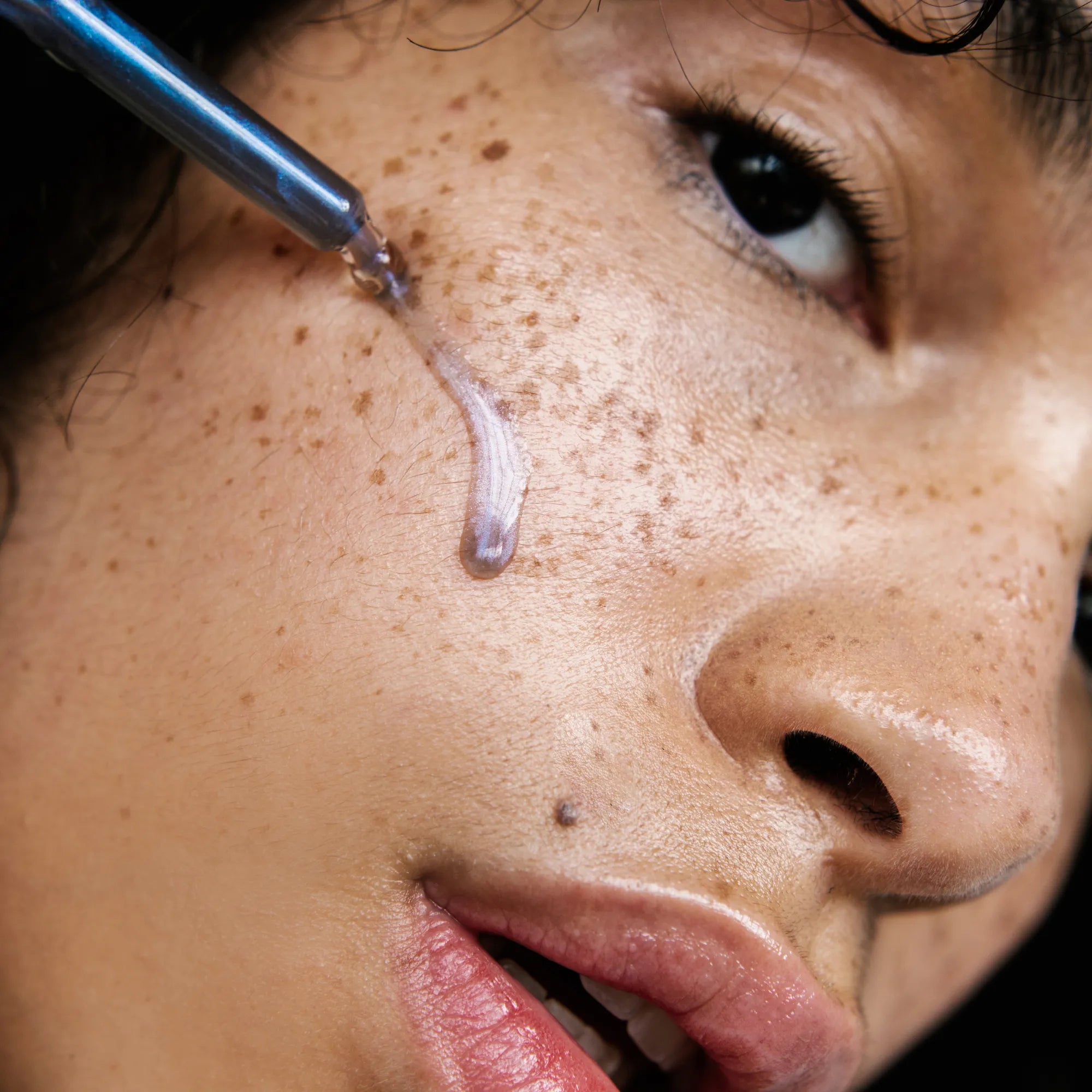 sérum bleu irisé appliqué sur visage femme