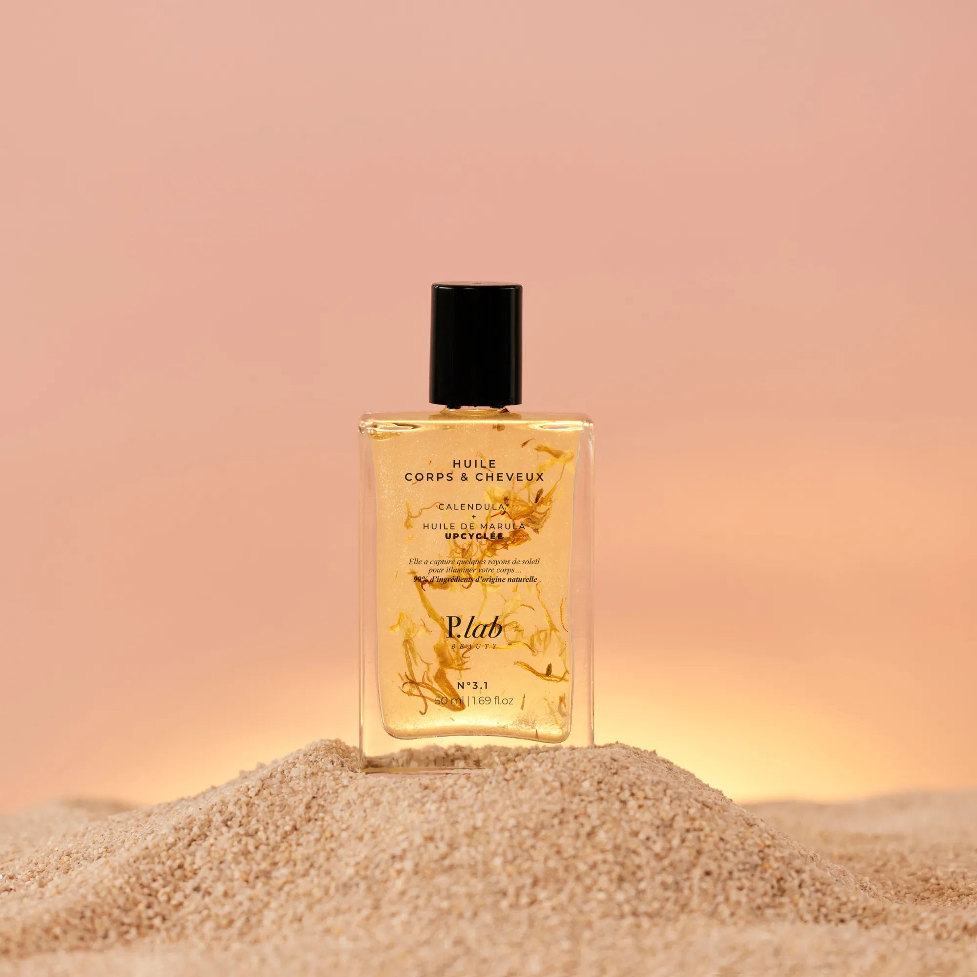 huile corps et cheveux sur sable fond coucher de soleil rose