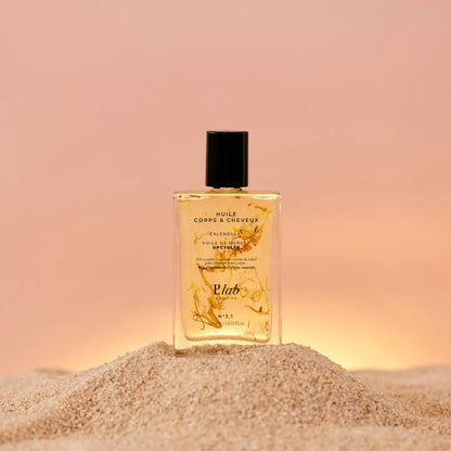 huile corps et cheveux jaune sur tas de sable fond coucher de soleil rose
