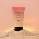 lait après solaire sur tas de sable fond coucher de soleil rose